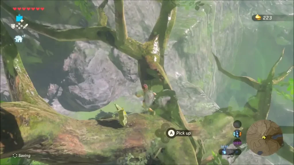Link on a tree branch about to pick up the stone