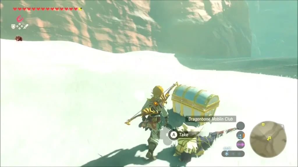 Link opening a chest in the snow at the foot of a rock face Link opening a chest in the snow at the foot of a rock face