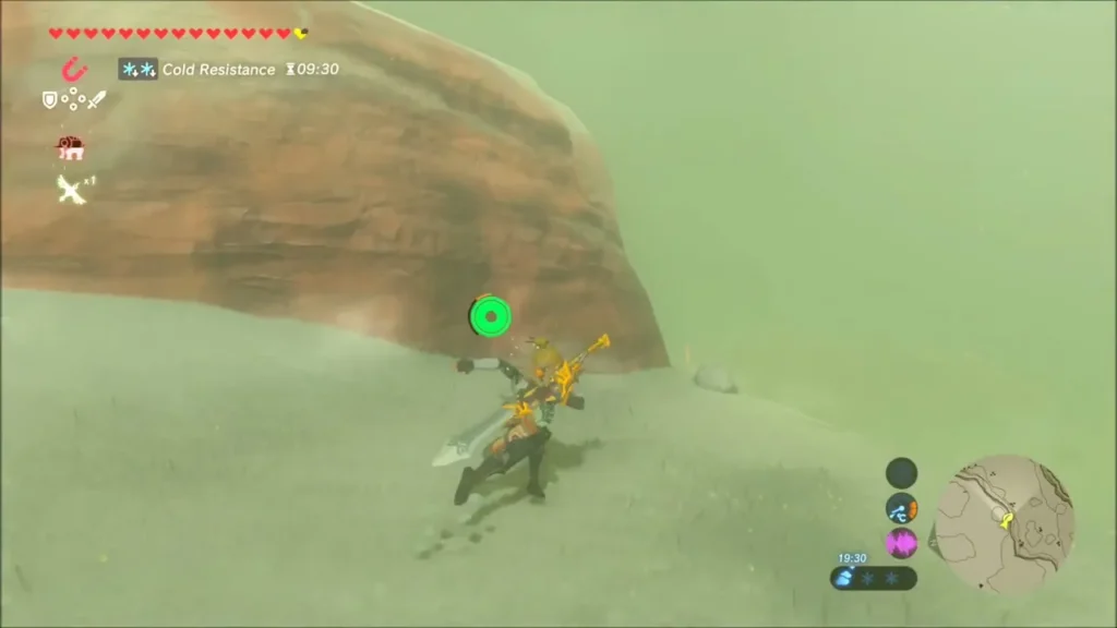 Link standing at the foot of a large red boulder in the snow Link standing at the foot of a large red boulder in the snow