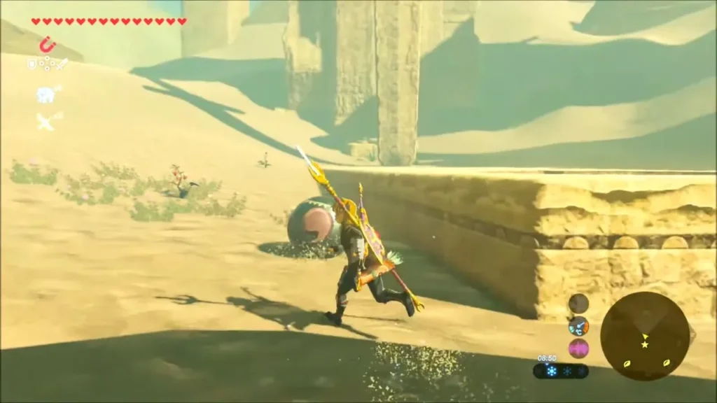 Link running beside a stone slab toward a rolling orb in the sand Link running beside a stone slab toward a rolling orb in the sand