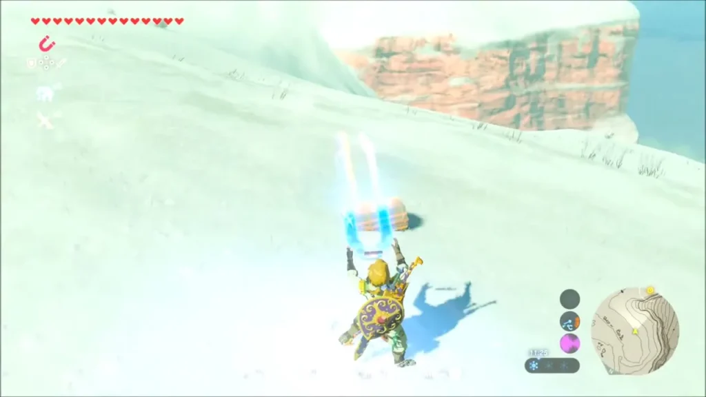Link using Magnesis to lift a chest buried in the snow Link using Magnesis to lift a chest buried in the snow