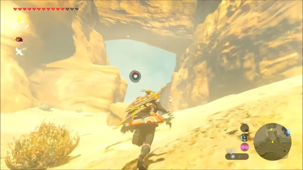 Link climbing a sandy slope toward a natural rock arch Link climbing a sandy slope toward a natural rock arch