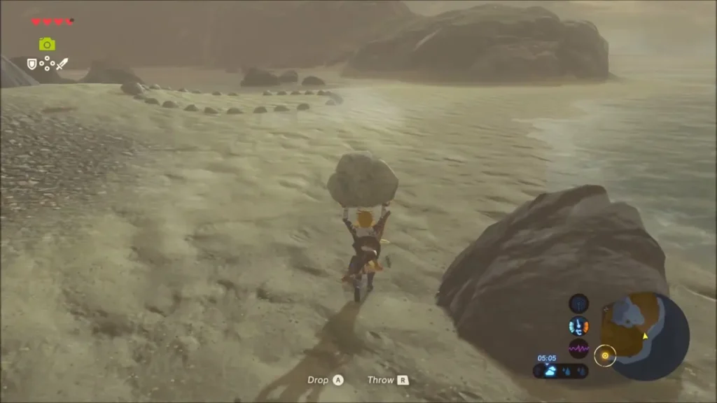 Link carrying a rock along the shore towards a ring of stones