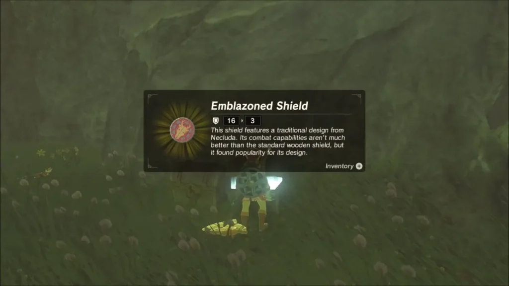 Link picking up the Emblazoned Shield from a chest in the grass