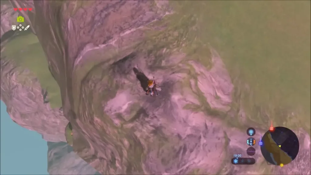 Link climbing a tall pink-and-brown sea cliff