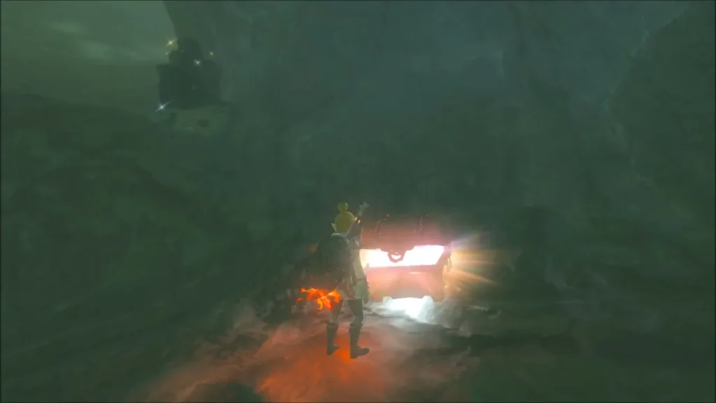 Link standing beside a glowing treasure chest at the back of the cave Link standing beside a glowing treasure chest at the back of the cave