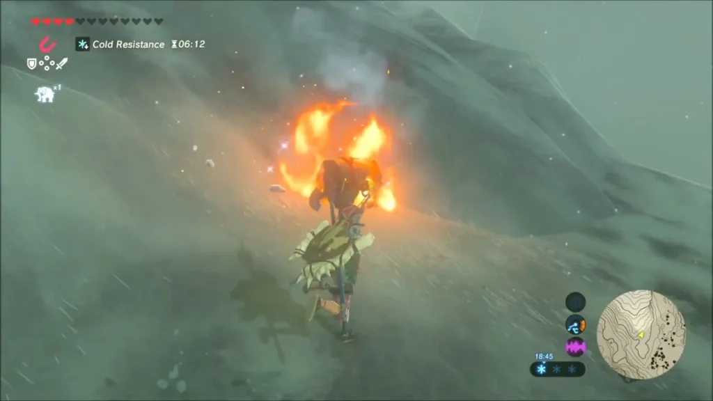 A Lizalfos engulfed in flames on the snowy hillside as Link watches A Lizalfos engulfed in flames on the snowy hillside as Link watches