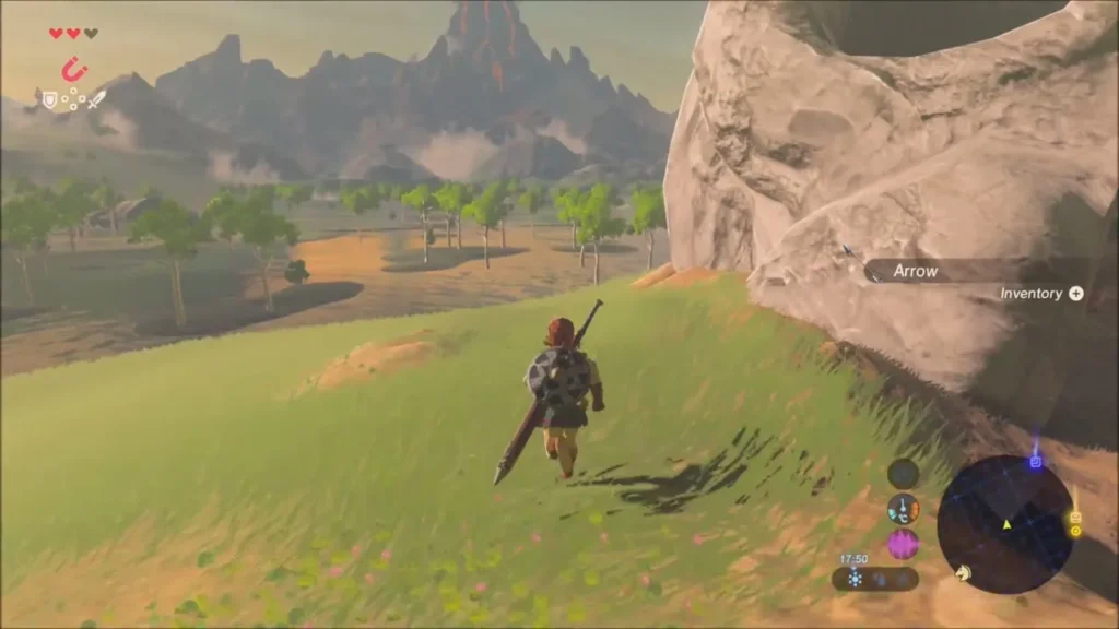 Link walking east past the skull rock across grassland toward distant mountains at dusk Link walking east past the skull rock across grassland toward distant mountains at dusk