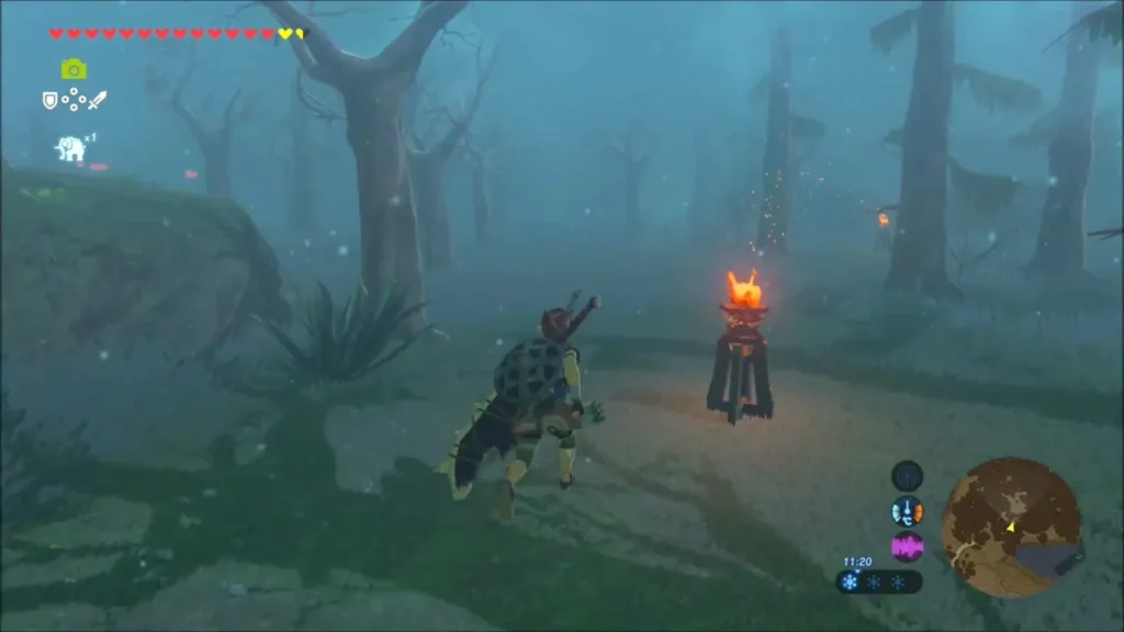 Link beside a lit torch in the fog of the Lost Woods
