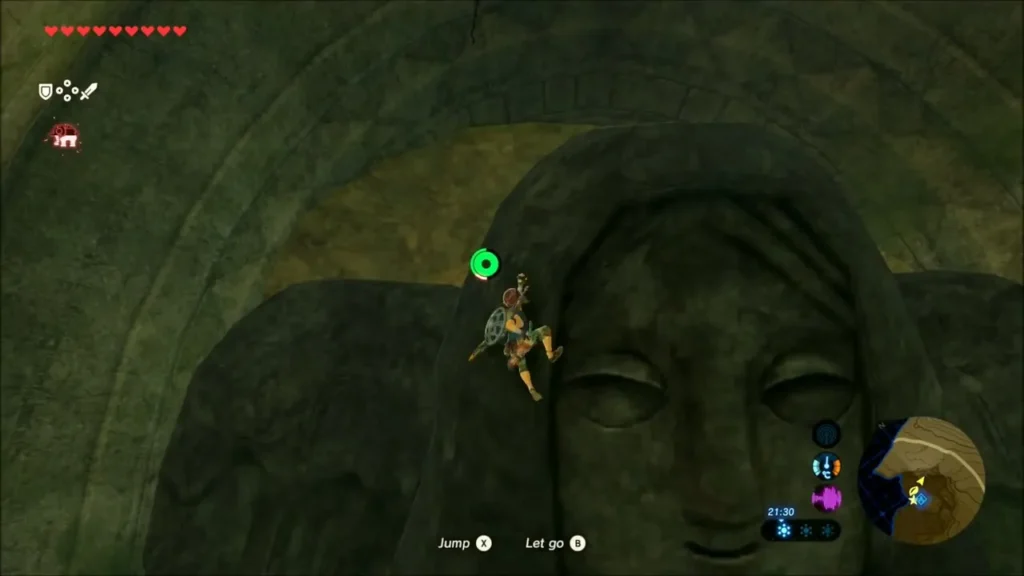 Link clinging near the statue's carved face higher up