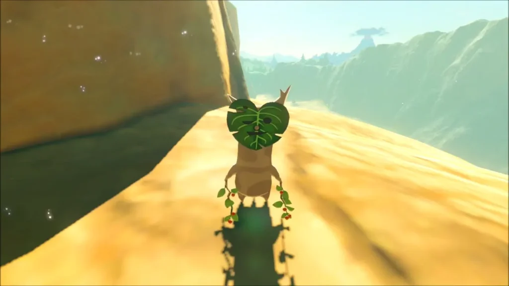 A Korok with a leaf mask standing on a sandy cliff ledge A Korok with a leaf mask standing on a sandy cliff ledge