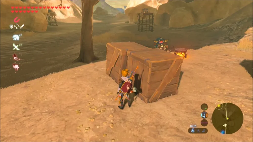 Link crouched behind crates by a Bokoblin camp on stilts Link crouched behind crates by a Bokoblin camp on stilts