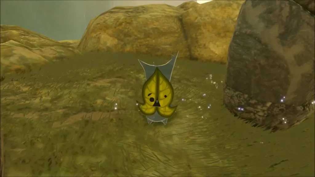 A yellow Korok standing on dry ground near the statues A yellow Korok standing on dry ground near the statues