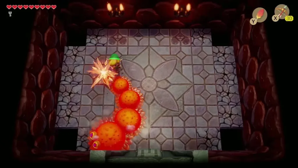 Link fighting a fiery segmented enemy in a chamber dungeon room Link fighting a fiery segmented enemy in a chamber dungeon room