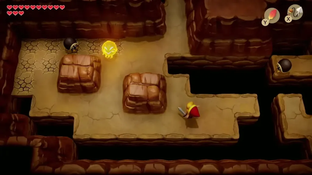 Link in the dark cave with bombable cracked walls and boulders