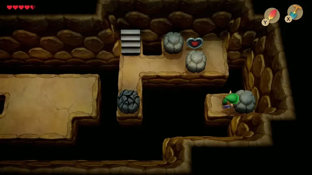 Link on a small ledge beside a rock in the cave
