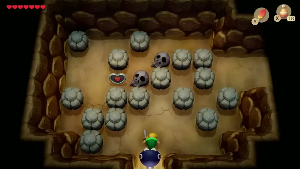Cave room full of grey rocks and skulls with a heart on the floor