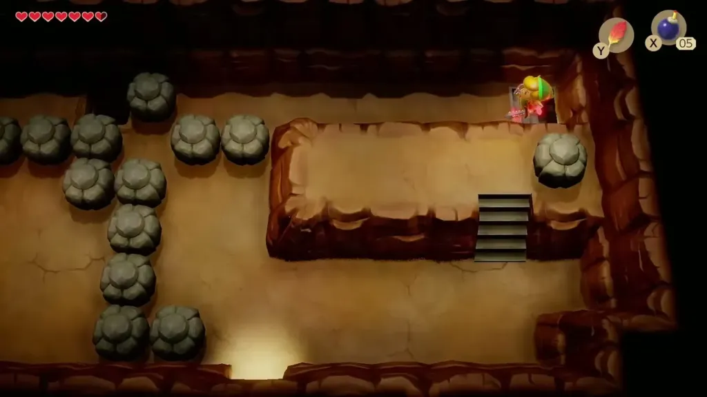 Link on the raised ledge by the stairs in the cave with stones around Link on the raised ledge by the stairs in the cave with stones around