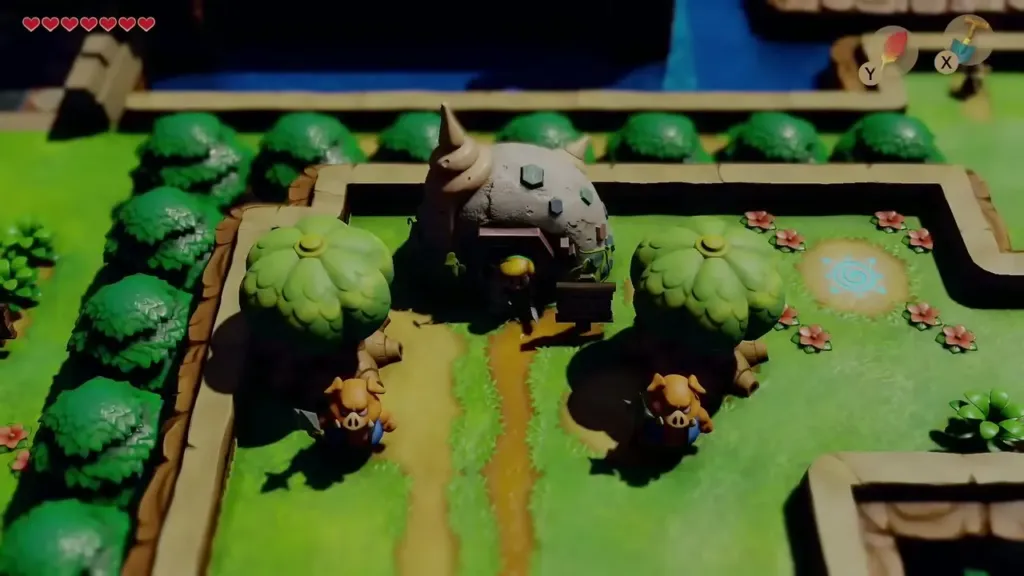 Link at the entrance of the Seashell Mansion with the grassy hill beside it Link at the entrance of the Seashell Mansion with the grassy hill beside it