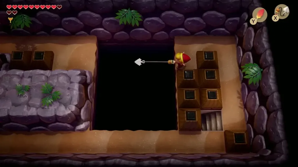 Link firing the Hookshot across the pit to the left Link firing the Hookshot across the pit to the left