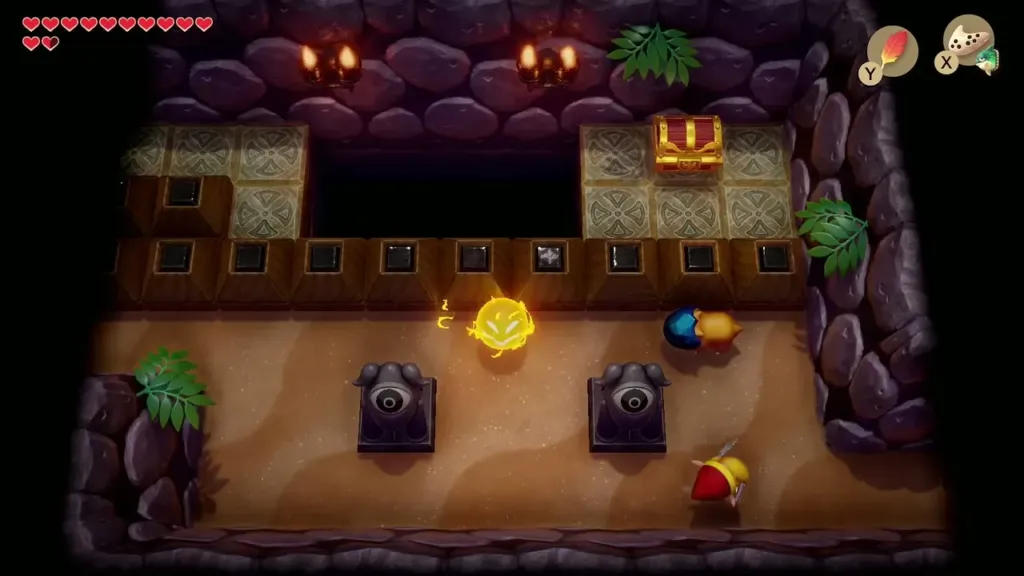 Link and a Spark in a sandy room with eye statues and a chest across a gap Link and a Spark in a sandy room with eye statues and a chest across a gap