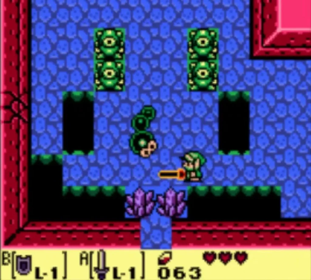 Link slashes a Mini-Moldorm in a blue-tiled room with purple crystals below Link slashes a Mini-Moldorm in a blue-tiled room with purple crystals below