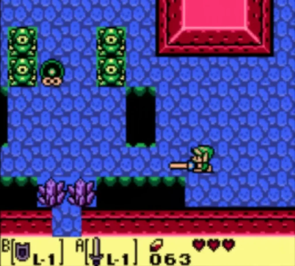 A Mini-Moldorm wriggling between green statues in Tail Cave with Link ready A Mini-Moldorm wriggling between green statues in Tail Cave with Link ready
