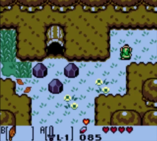 Red Recovery Heart lies on pale ground beside dark boulders, with Link in his green tunic at the top right Red Recovery Heart lies on pale ground beside dark boulders, with Link in his green tunic at the top right
