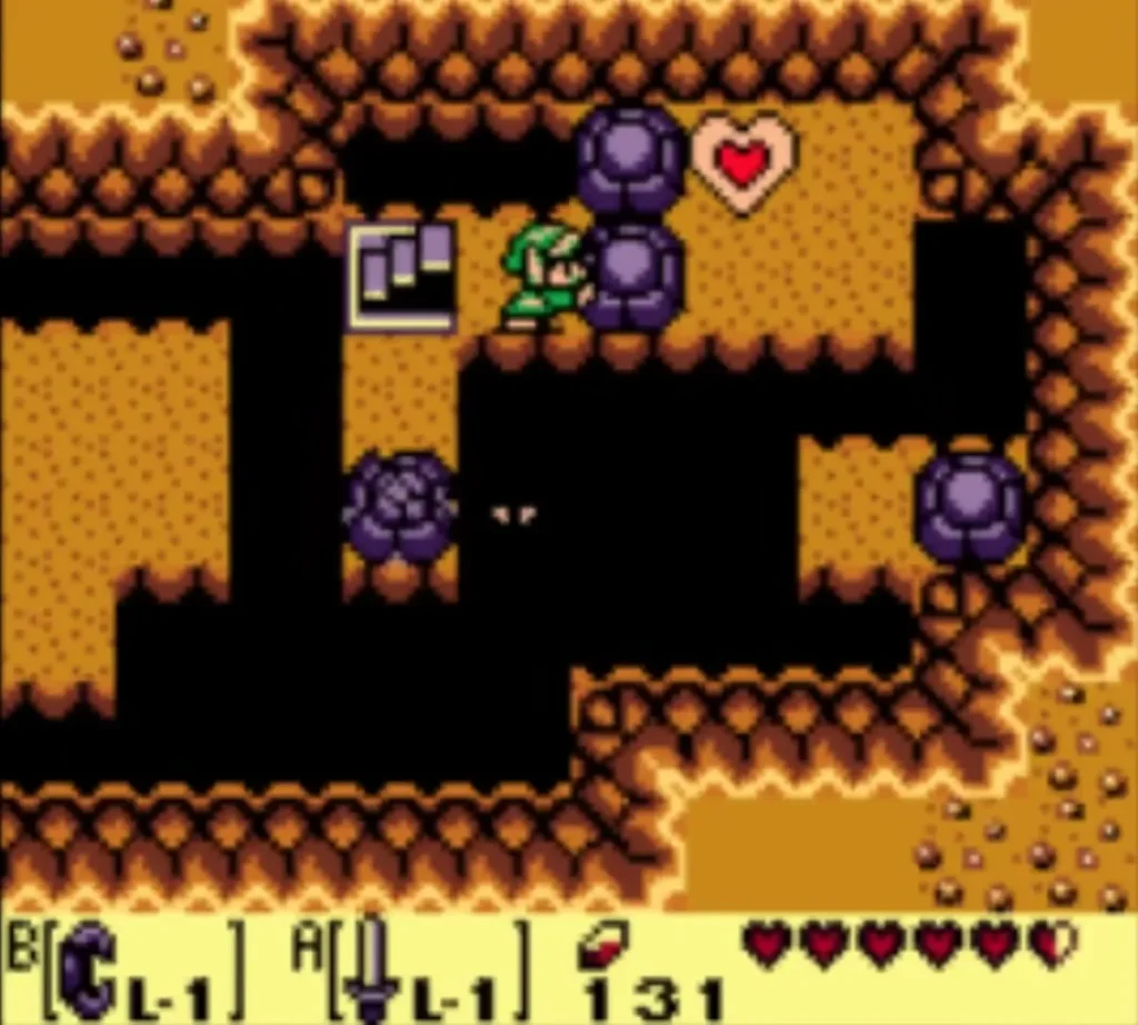 Link stands in the grave cave beside a purple rock, with a Piece of Heart on the ledge beyond Link stands in the grave cave beside a purple rock, with a Piece of Heart on the ledge beyond