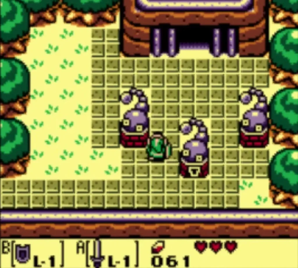 Link stands between purple statues in the tiled courtyard that leads to Tail Cave Link stands between purple statues in the tiled courtyard that leads to Tail Cave