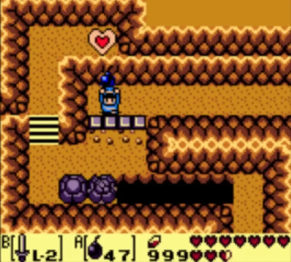 Link on the cave floor beside a purple boulder, a heart pickup above and a pit to the right.