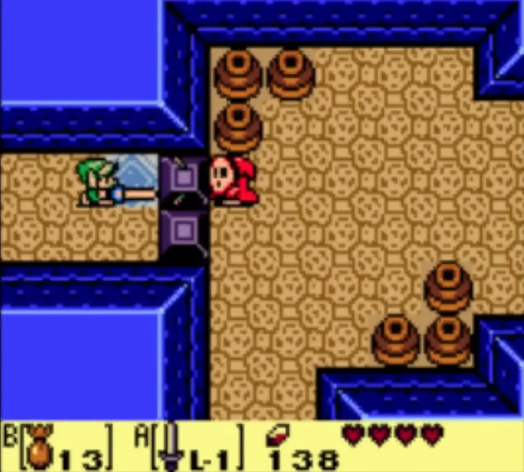 Link striking a red Shy Guy beside the purple blocks in the sandy room Link striking a red Shy Guy beside the purple blocks in the sandy room