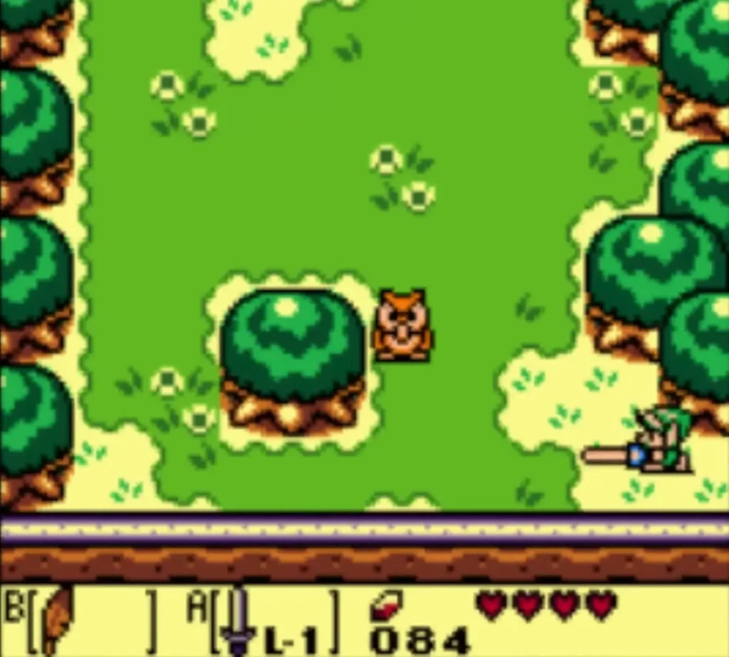 The Owl stands on the grass beside a round bush as Link swings his Sword at the right edge The Owl stands on the grass beside a round bush as Link swings his Sword at the right edge