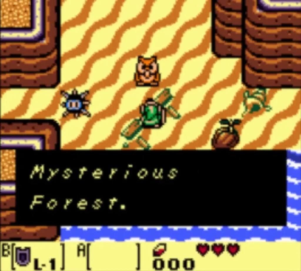 An Owl text box names the Mysterious Forest as Link stands on the beach An Owl text box names the Mysterious Forest as Link stands on the beach