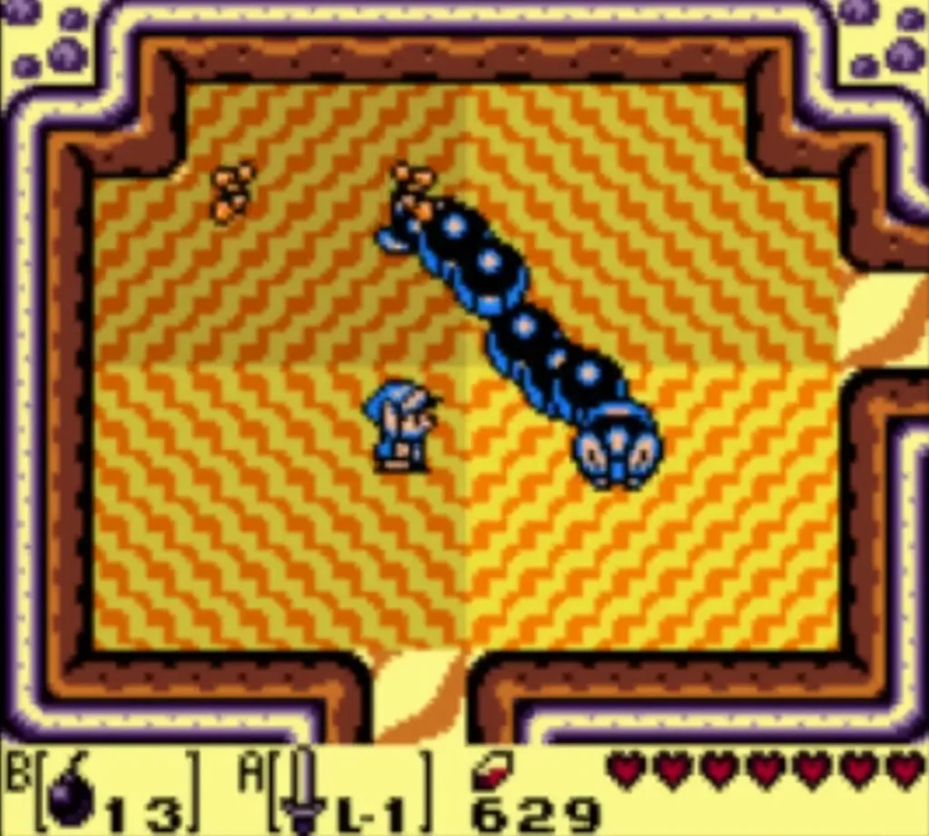 Link in a sandy cave room as the blue Lanmola segments cross toward him Link in a sandy cave room as the blue Lanmola segments cross toward him