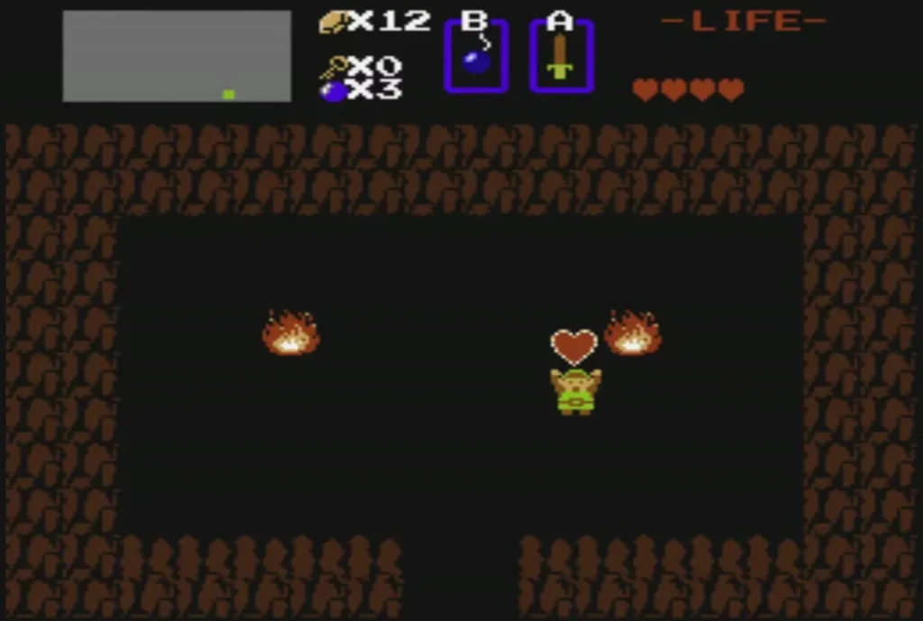 Link standing beside a heart in the Old Man's cave, with two fires Link standing beside a heart in the Old Man's cave, with two fires