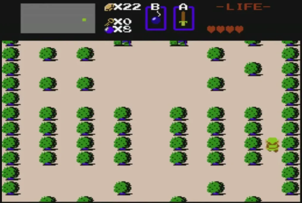 A green Zol blob resting in a sand field beside bushes