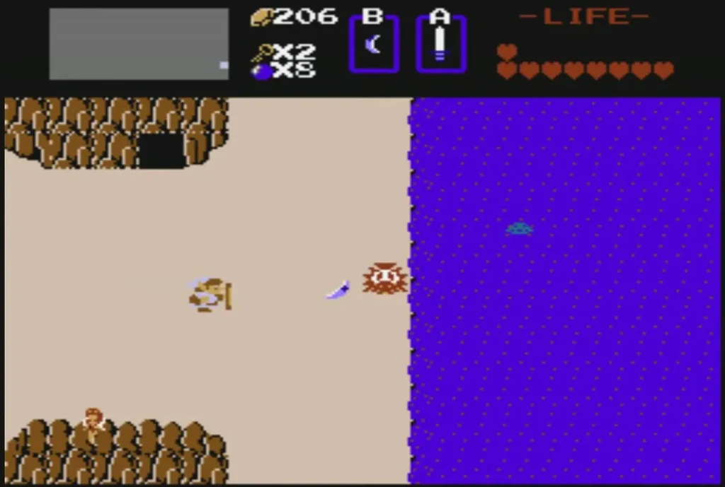 Sand shore beside a lake with a dark cave entrance in the top-left rock wall Sand shore beside a lake with a dark cave entrance in the top-left rock wall