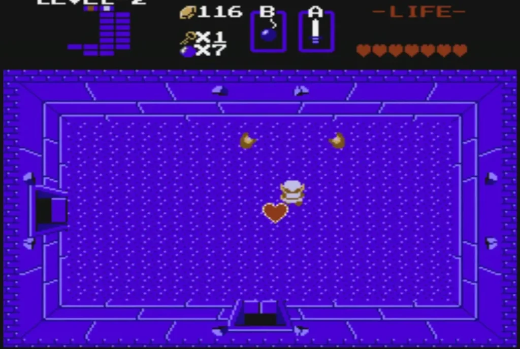 A heart lies on the boss room floor after Dodongo falls, with Link standing beside it A heart lies on the boss room floor after Dodongo falls, with Link standing beside it
