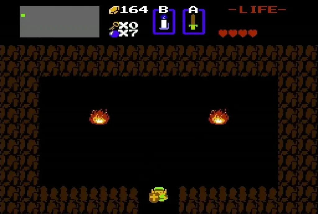 Link standing in a dark cave between two fires Link standing in a dark cave between two fires