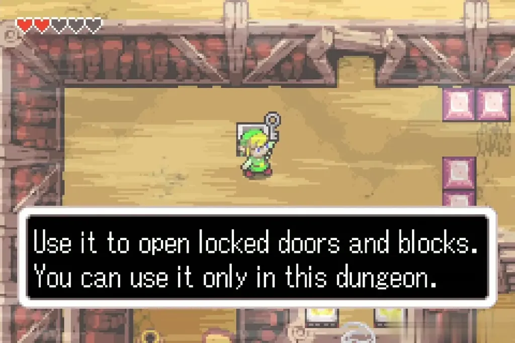 Link holding a small key overhead in the Cave of Flames with the full key description box Link holding a small key overhead in the Cave of Flames with the full key description box