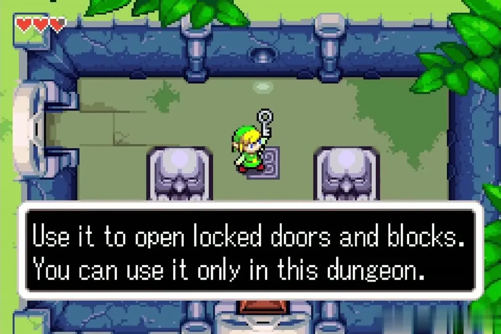 Link holding a small key overhead in a statue room while the key description box shows Link holding a small key overhead in a statue room while the key description box shows