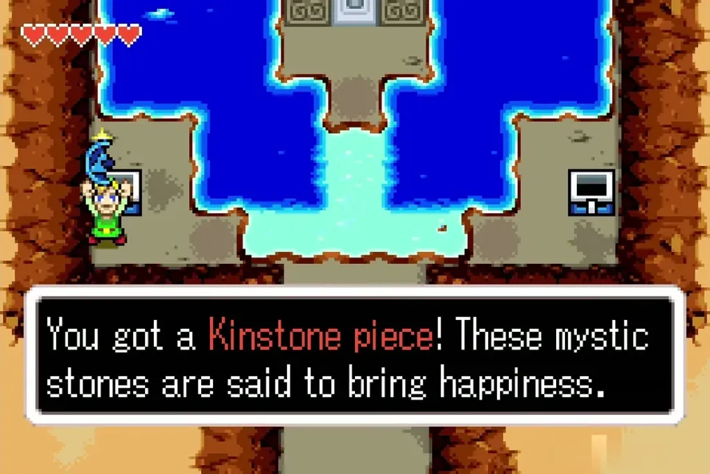 Link holding a Kinstone piece in the water cave Link holding a Kinstone piece in the water cave