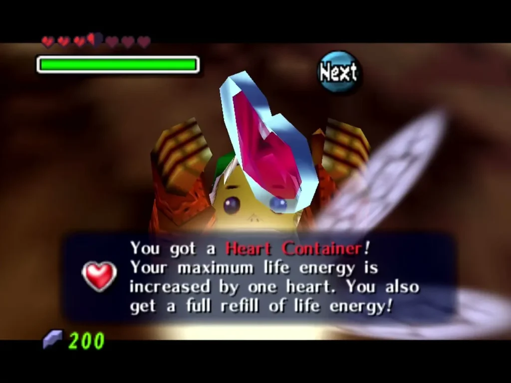 Link holds up a Heart Container with Tatl's wing beside him, the box saying he gets a full refill of life energy Link holds up a Heart Container with Tatl's wing beside him, the box saying he gets a full refill of life energy