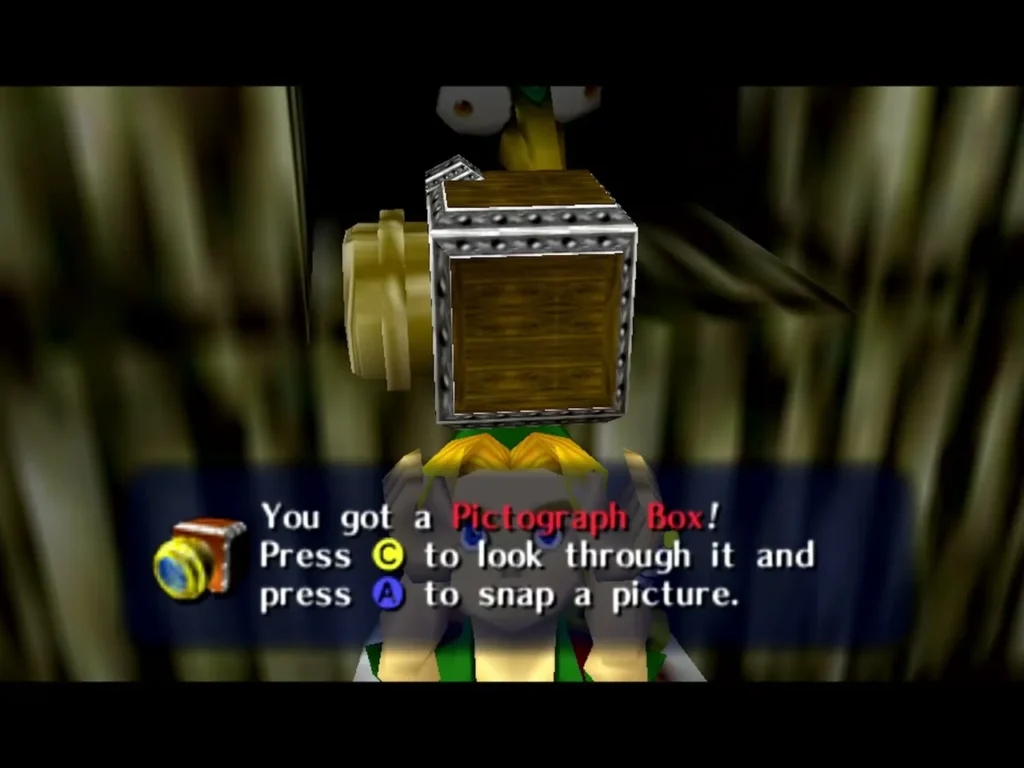 Link holds up the Pictograph Box under the box explaining how to look through it and snap a picture Link holds up the Pictograph Box under the box explaining how to look through it and snap a picture