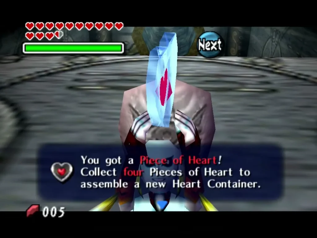 Link holds up a Piece of Heart with the message box reading collect four pieces to assemble a Heart Container Link holds up a Piece of Heart with the message box reading collect four pieces to assemble a Heart Container