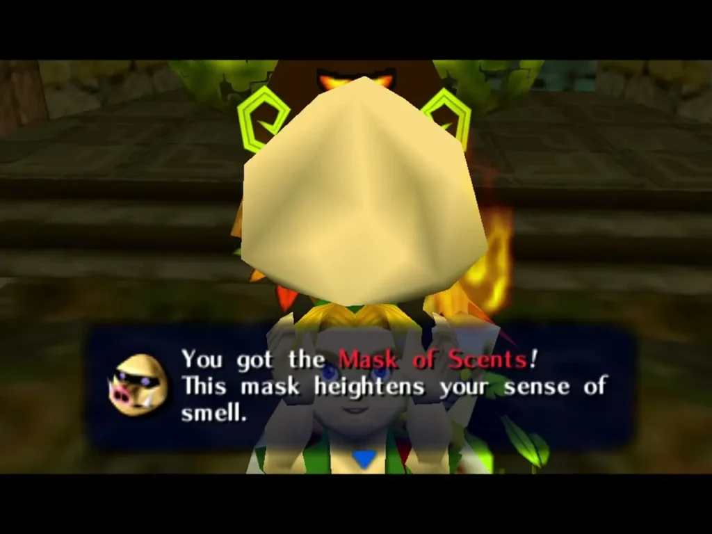 Link holding up the Mask of Scents with its name box on screen beside a torch Link holding up the Mask of Scents with its name box on screen beside a torch