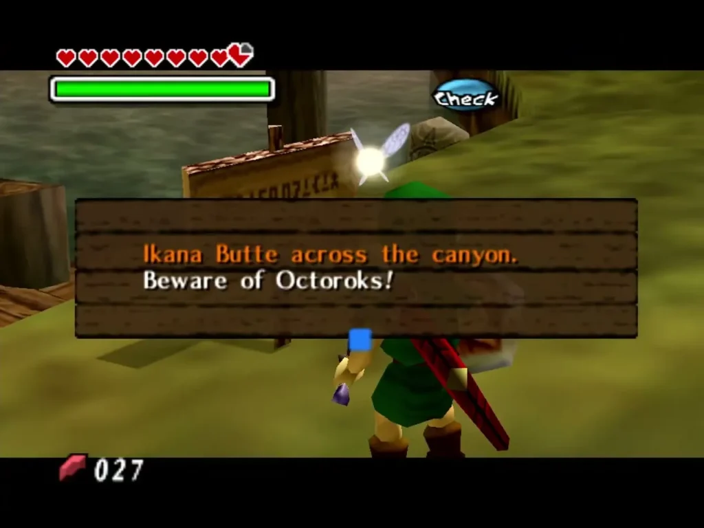 A wooden sign by the riverbank reads Ikana Butte across the canyon and warns Link to beware of Octoroks A wooden sign by the riverbank reads Ikana Butte across the canyon and warns Link to beware of Octoroks