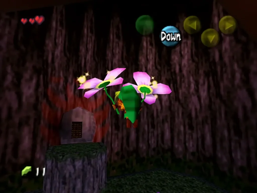 Deku Link gliding on two pink flowers beside a tree stump with a Down prompt Deku Link gliding on two pink flowers beside a tree stump with a Down prompt