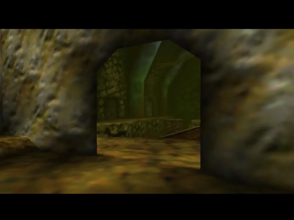 The rubble wall blasted open, revealing the green stone passage into the main cavern